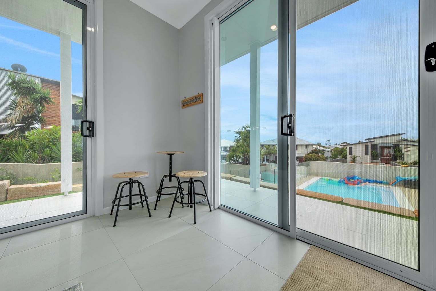 Interior Room with Sliding Glass Doors Overlooking a Pool — Wares Blinds, Screens & Awnings In Agnes Water, QLD