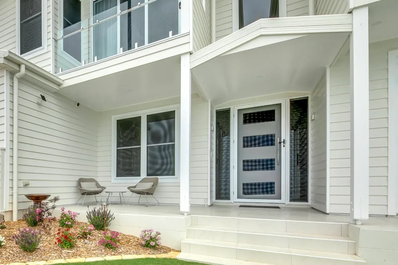 White House with Porch, Front Door, Two Chairs, and Landscaping — Wares Blinds, Screens & Awnings In Rockhampton, QLD