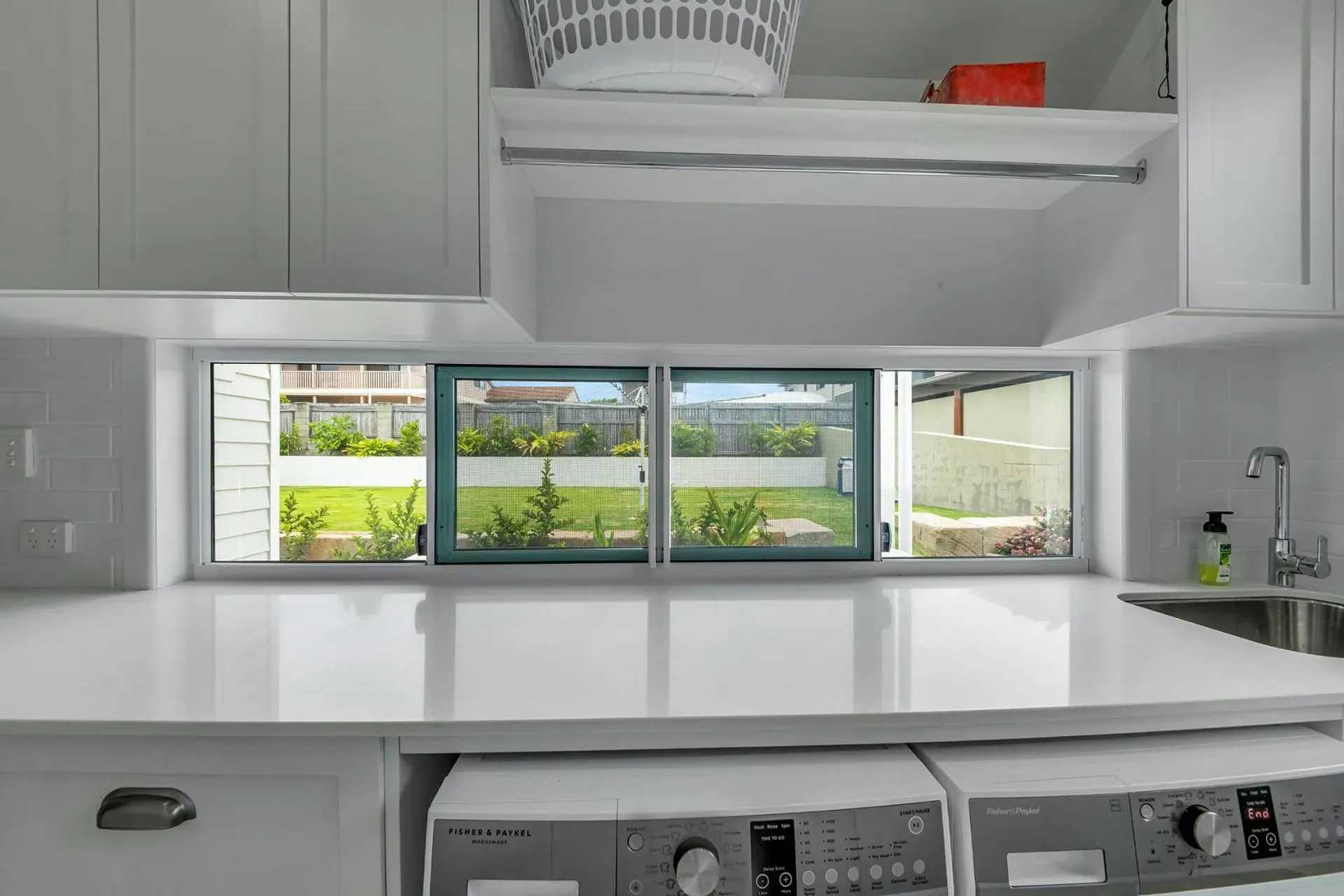 White Laundry Room with Washer/dryer, Countertop, Windows Overlooking Backyard — Wares Blinds, Screens & Awnings In Tannum Sands, QLD