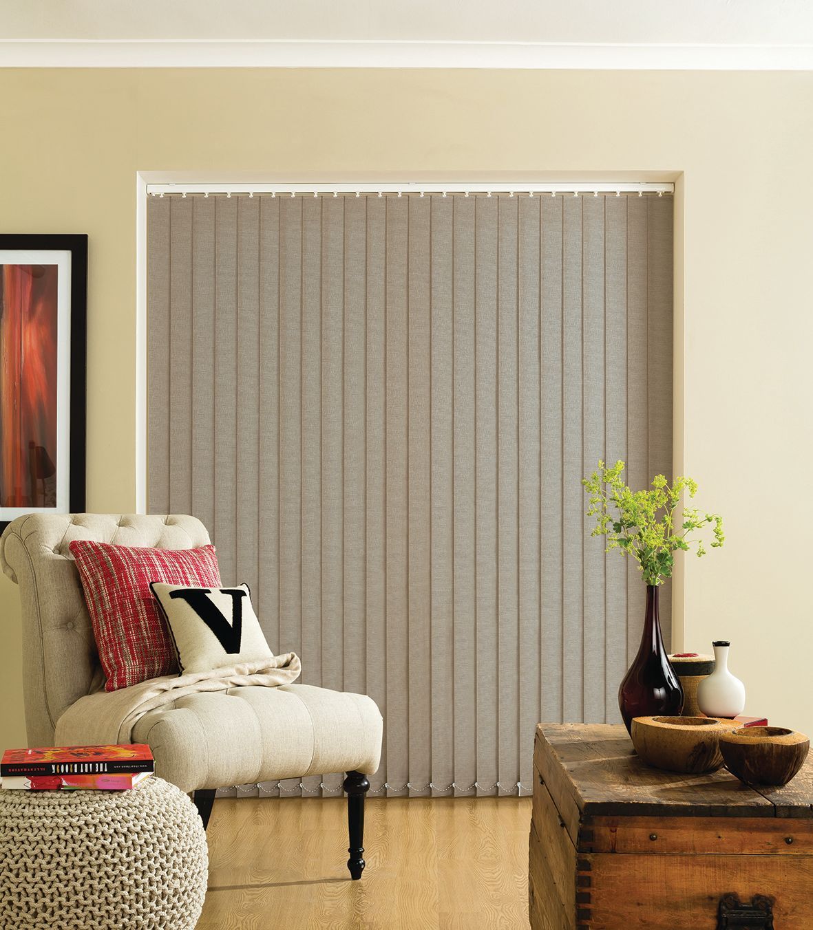Living room with beige vertical blinds, armchair, and wooden chest.