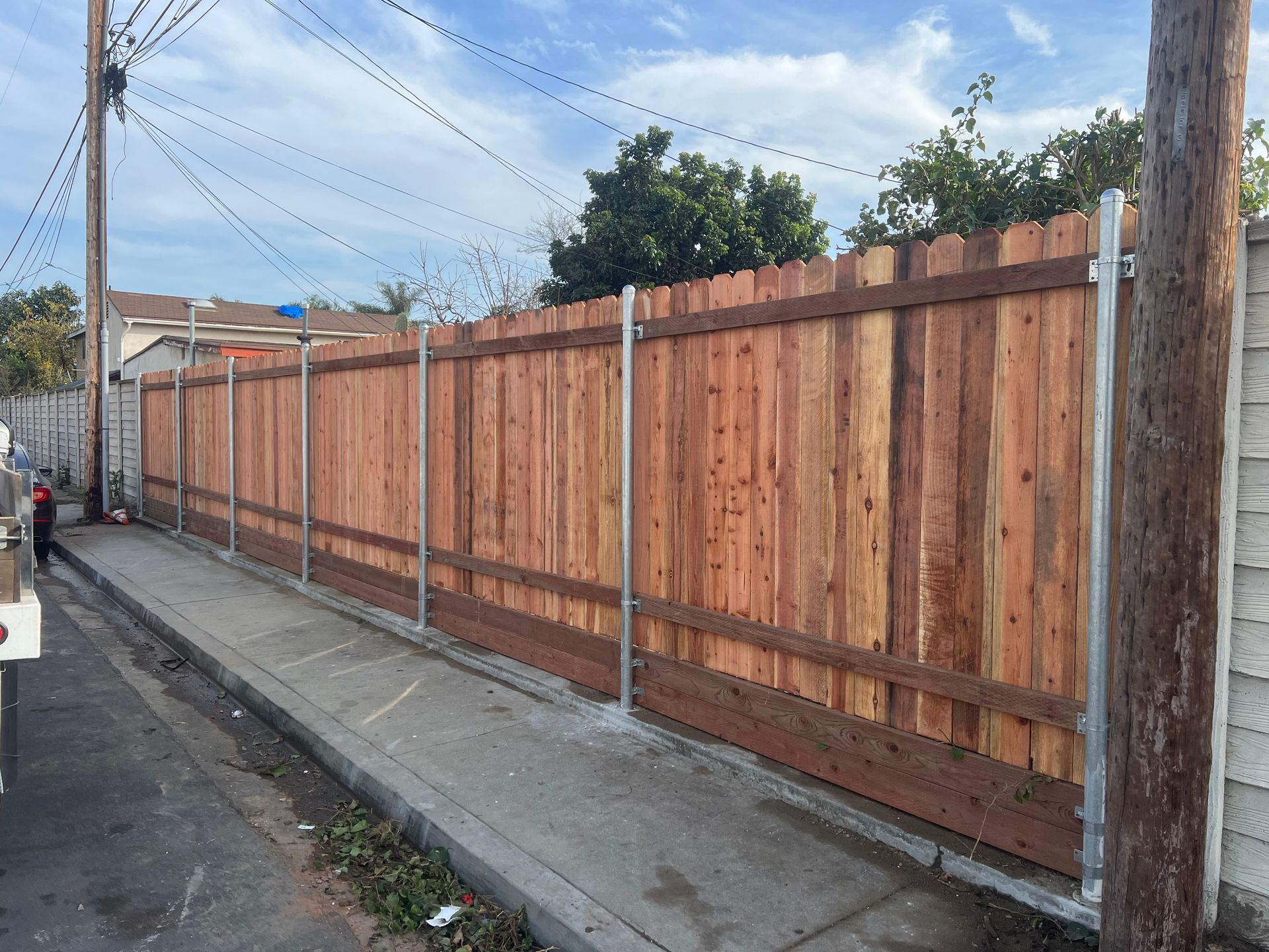 A wooden fence along the side of a street
