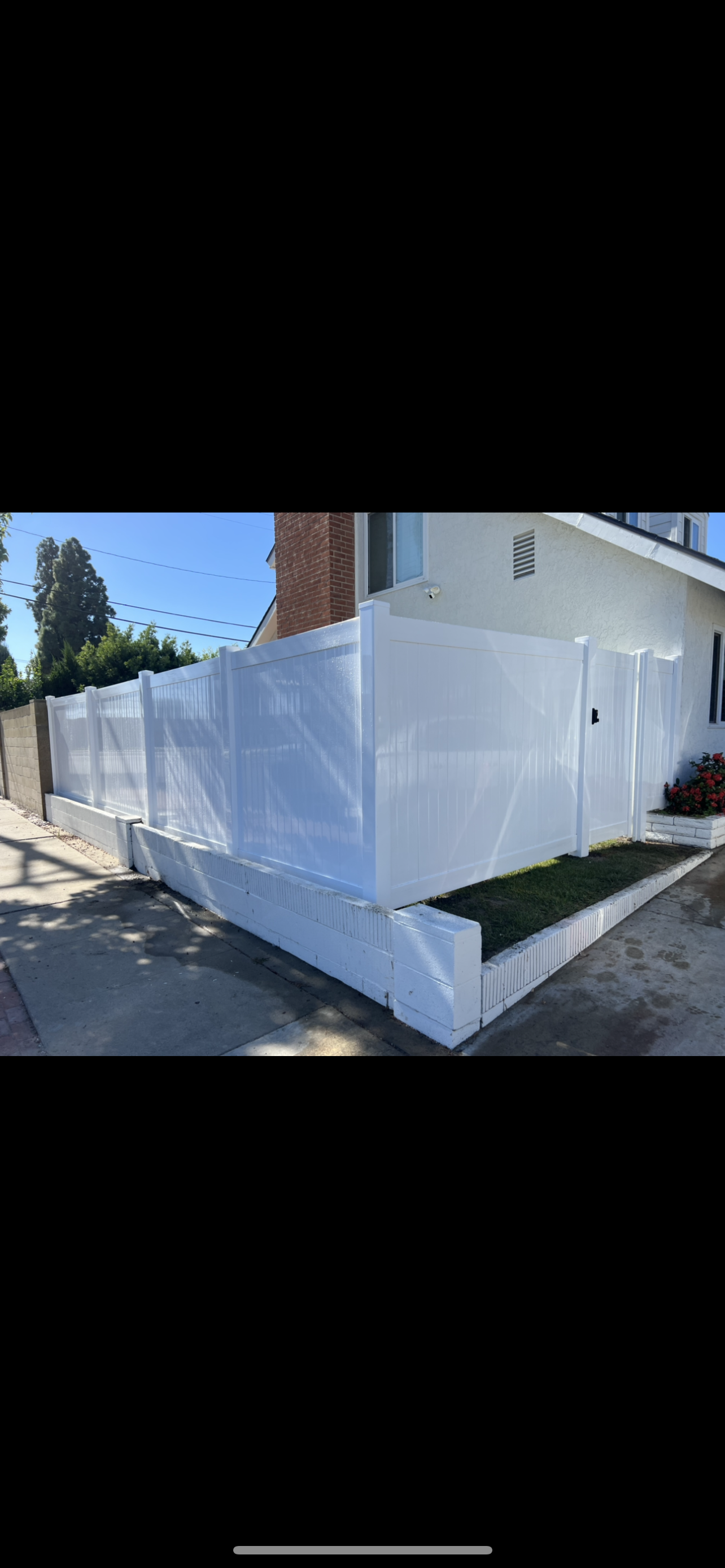 A white fence is sitting on the side of a house.