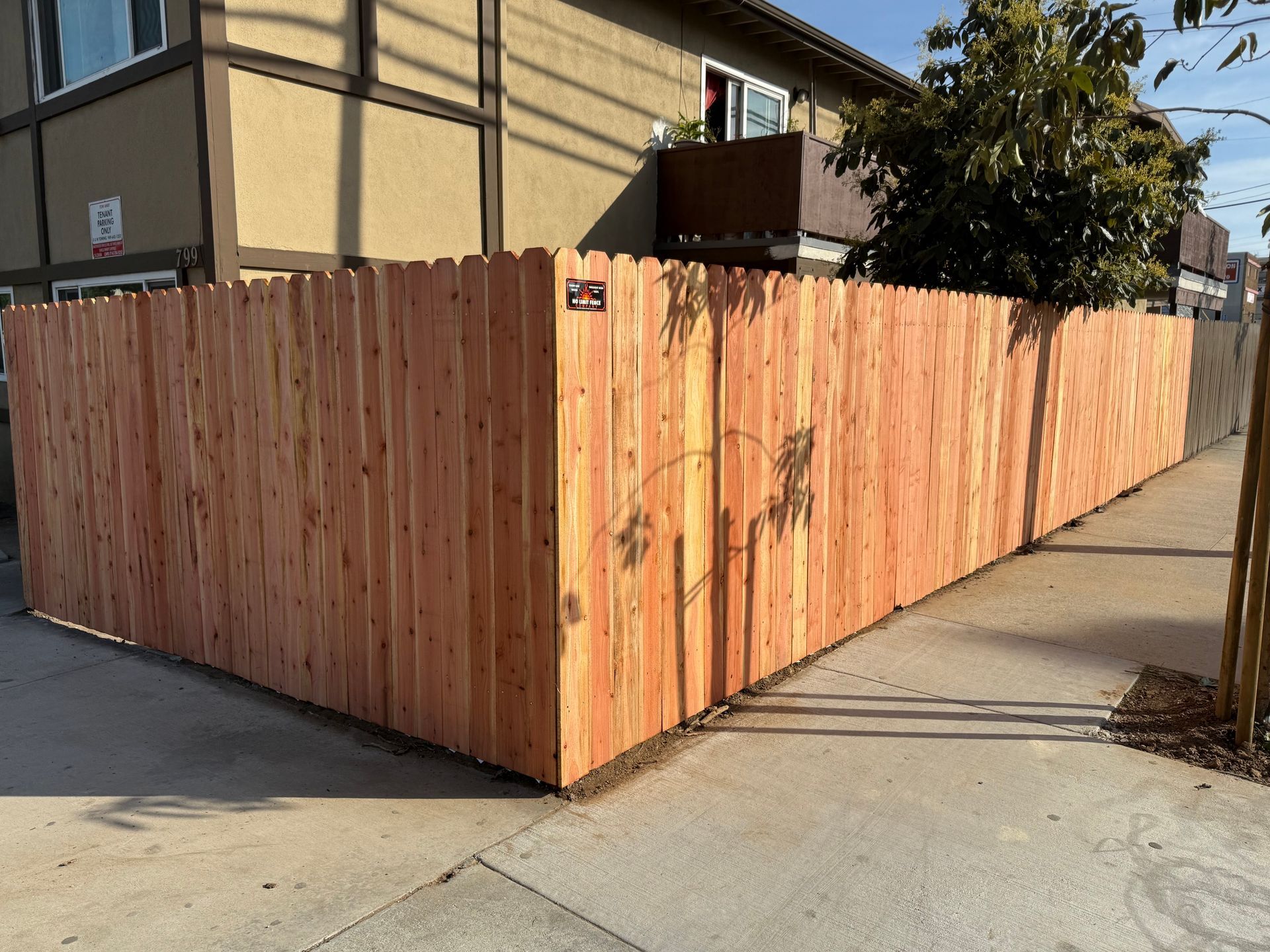 A wooden fence is sitting on the sidewalk in front of a building.