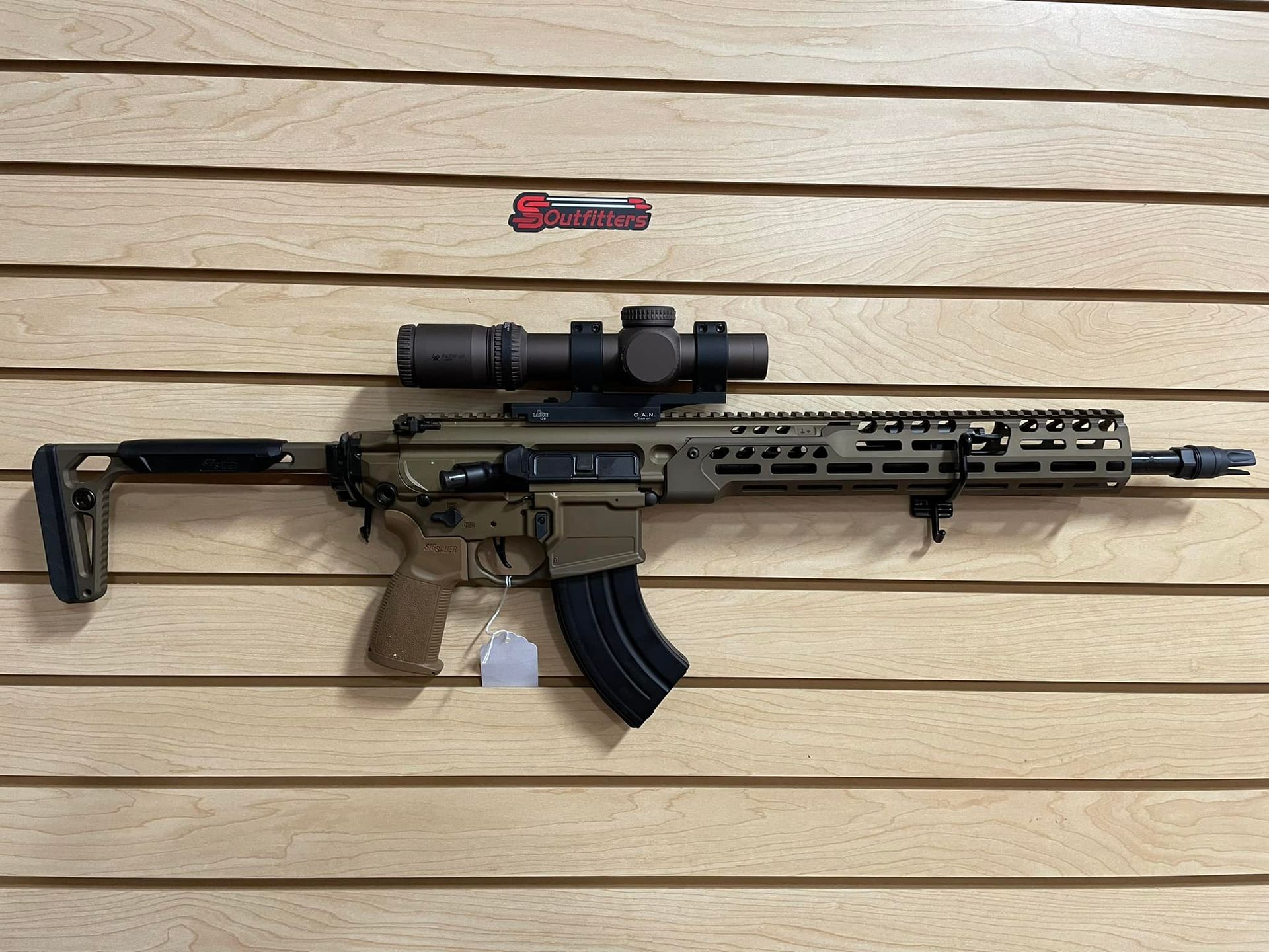  a gun is hanging on a wooden wall.