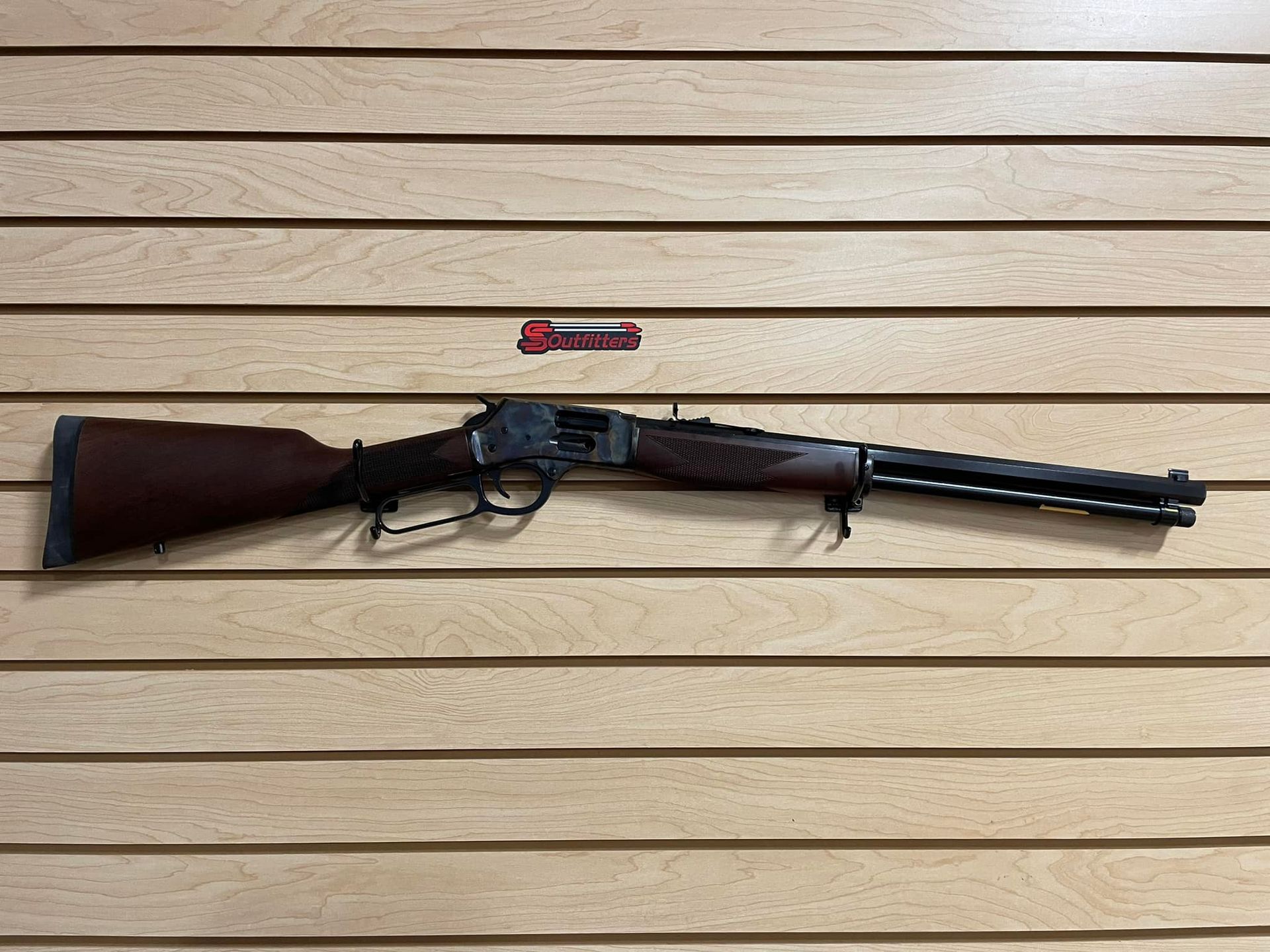 a gun is hanging on a wooden wall.