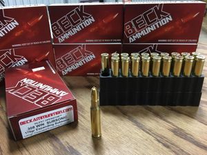 Boxes of beck ammunition are sitting on a wooden table.