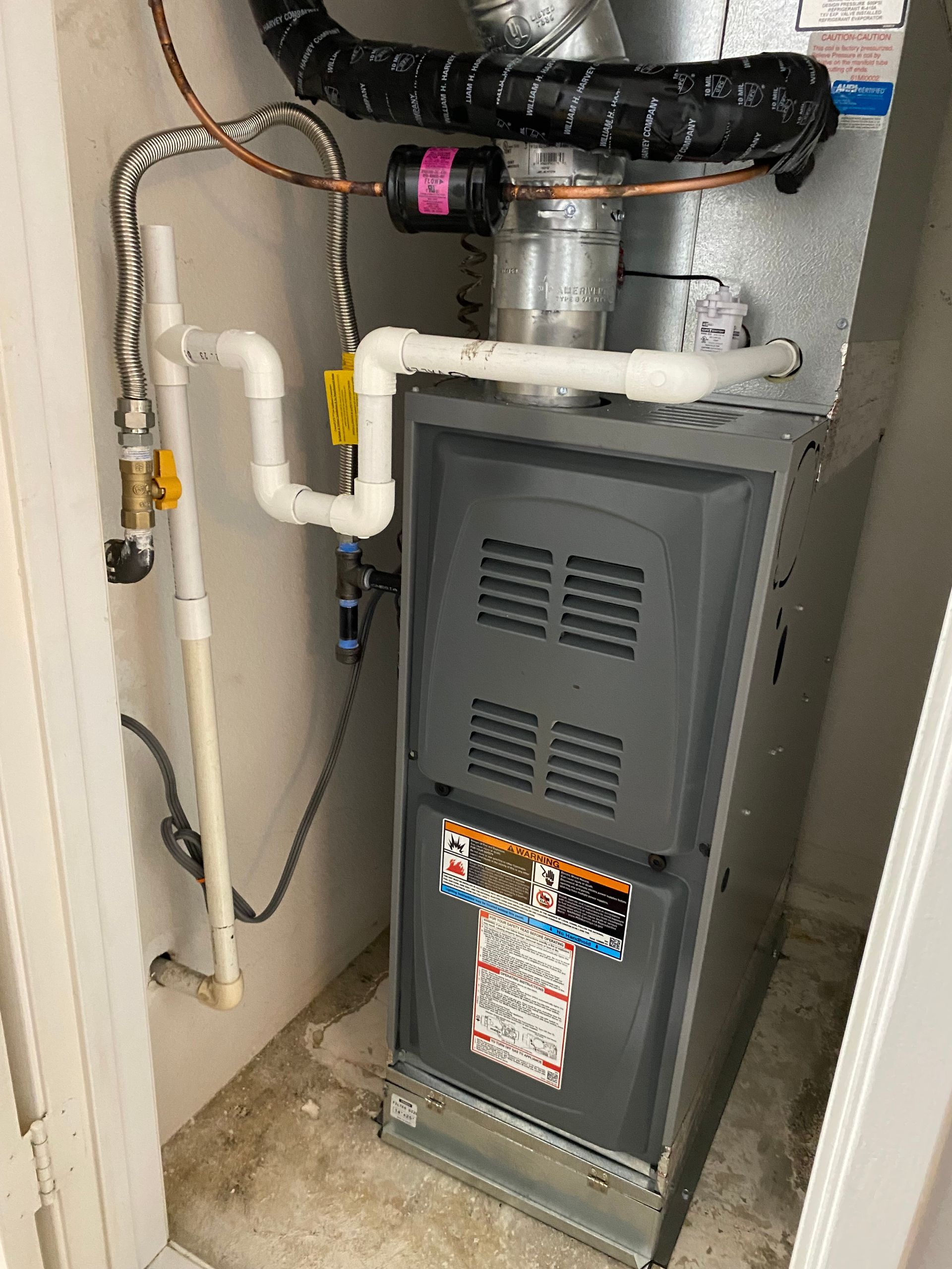 A furnace is sitting in a room next to a door.
