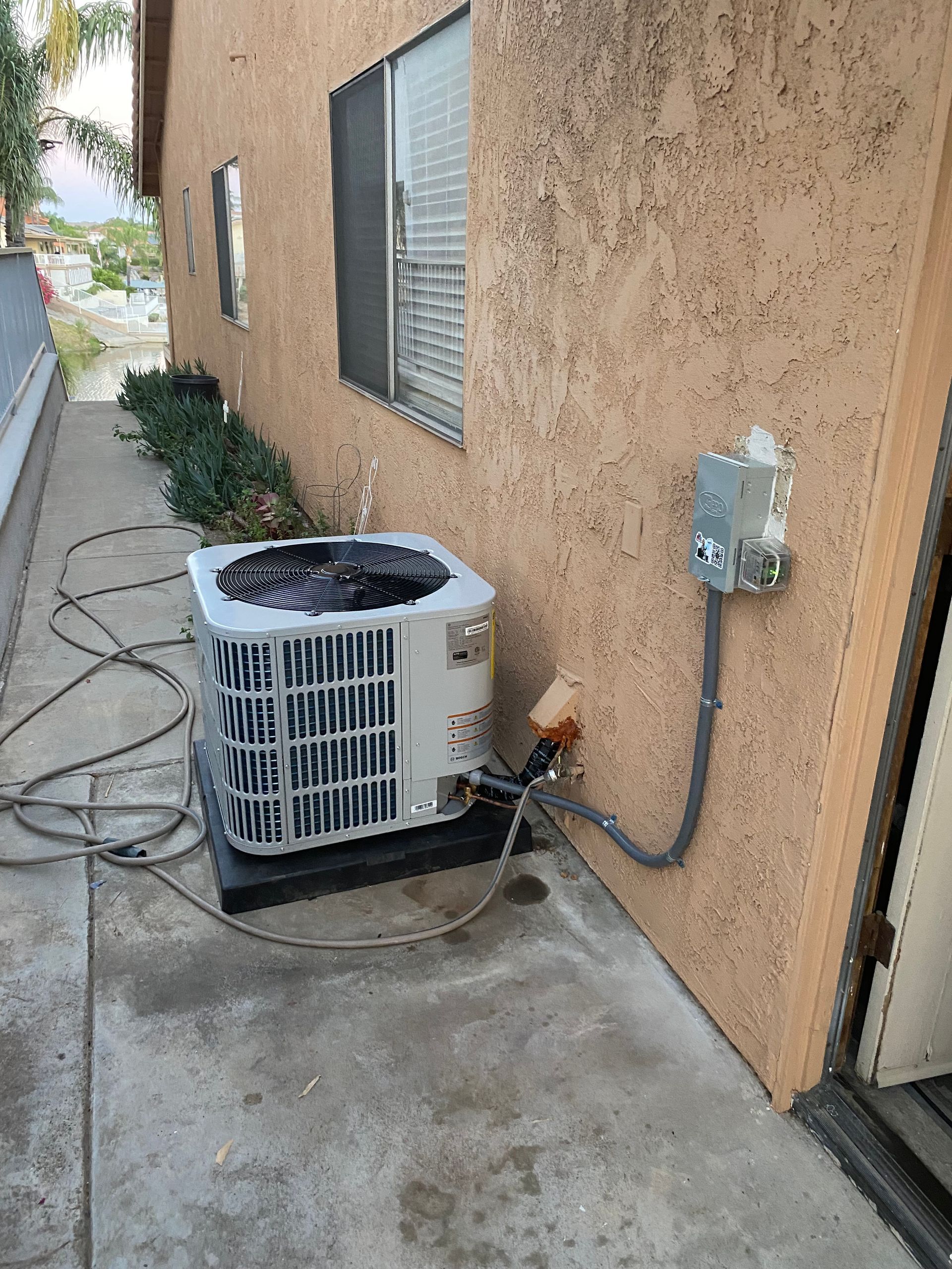 An air conditioner is sitting on the side of a building.