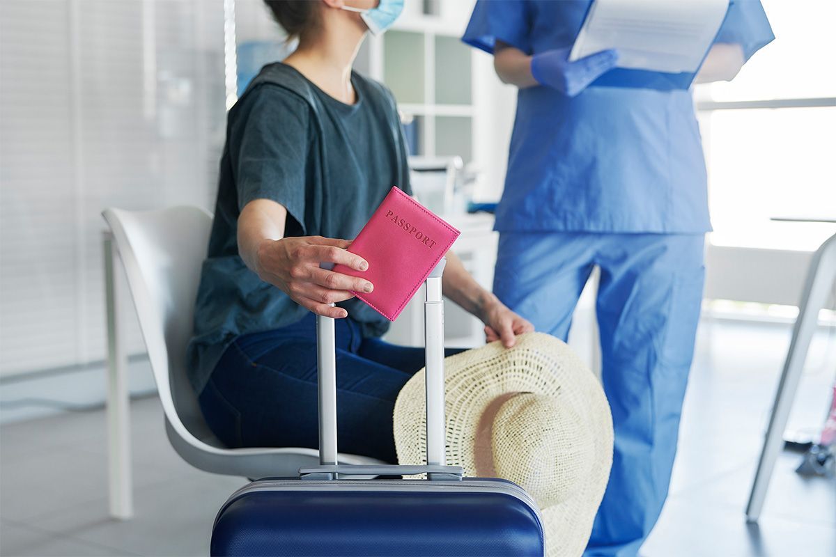 A patient speaking with a healthcare provider while holding a passport