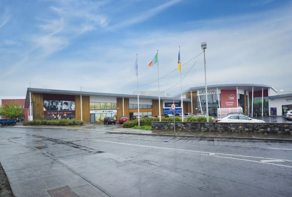 A large building with a lot of cars parked in front of it.