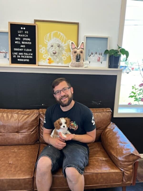 A Man is Sitting on a Couch Holding a Puppy | Springfield, MO | MMK9