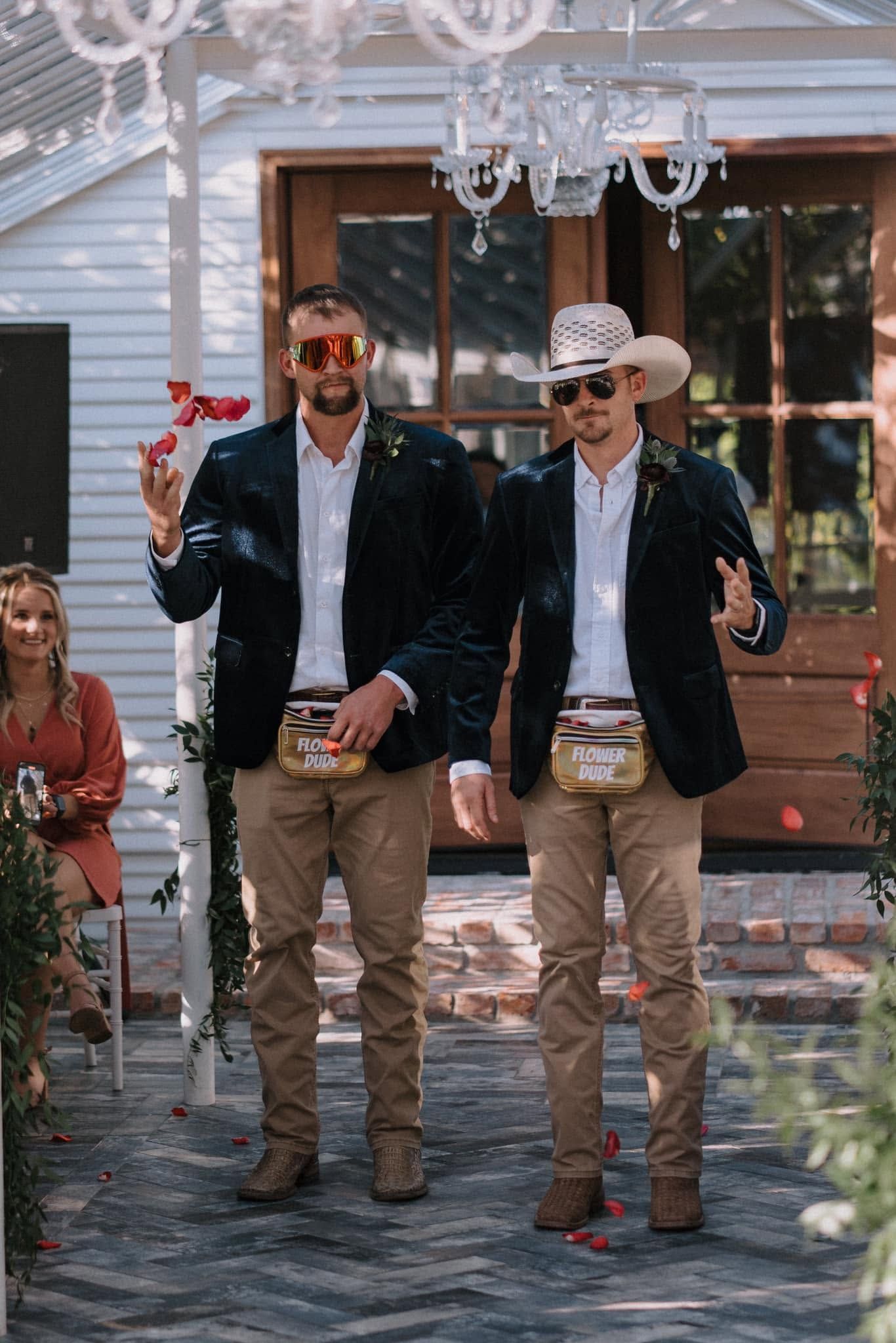 Two men in suits toast with champagne under a decorated outdoor canopy at a celebration