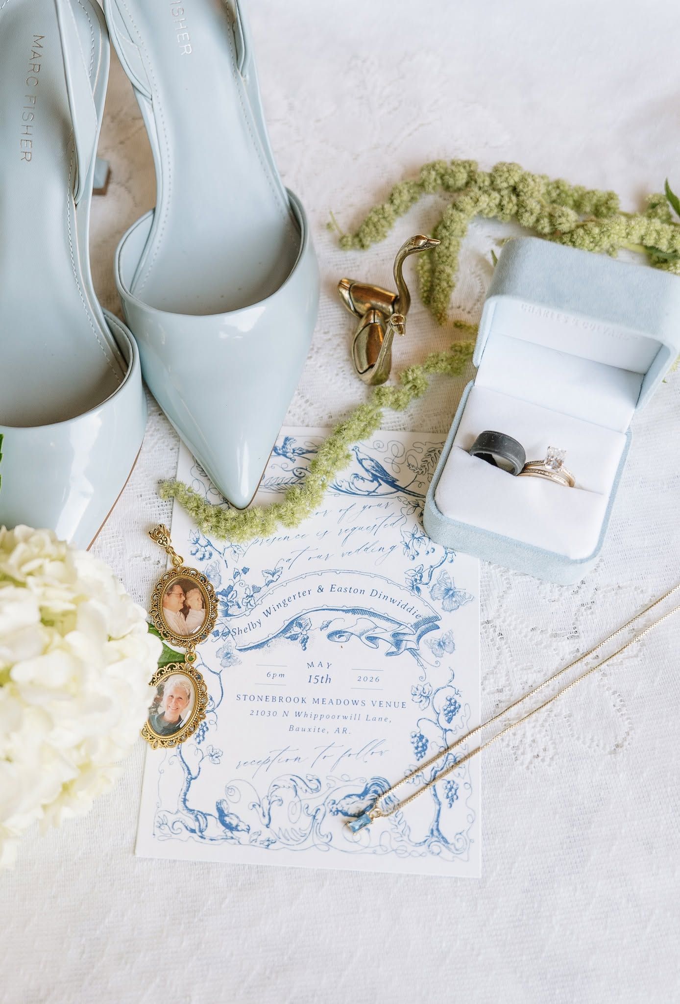 White bridal shoes with a green flower garland and a handwritten note on white fabric