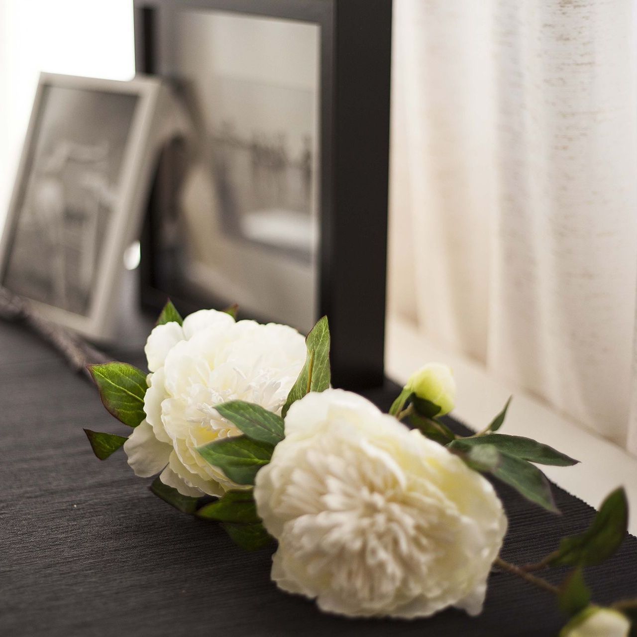 4 men carrying a casket with a flower arrangement on top