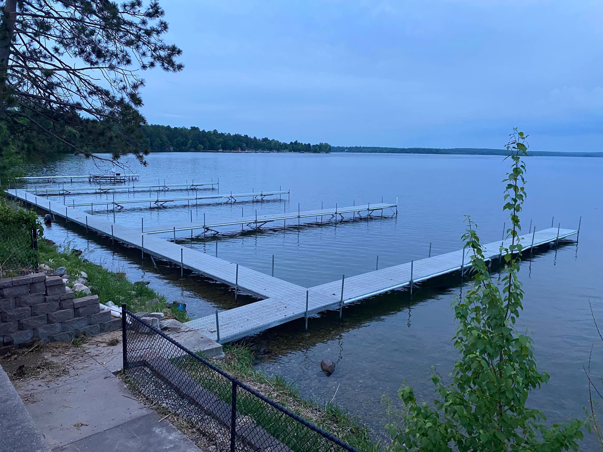 A large dock filled with boats on a lake.