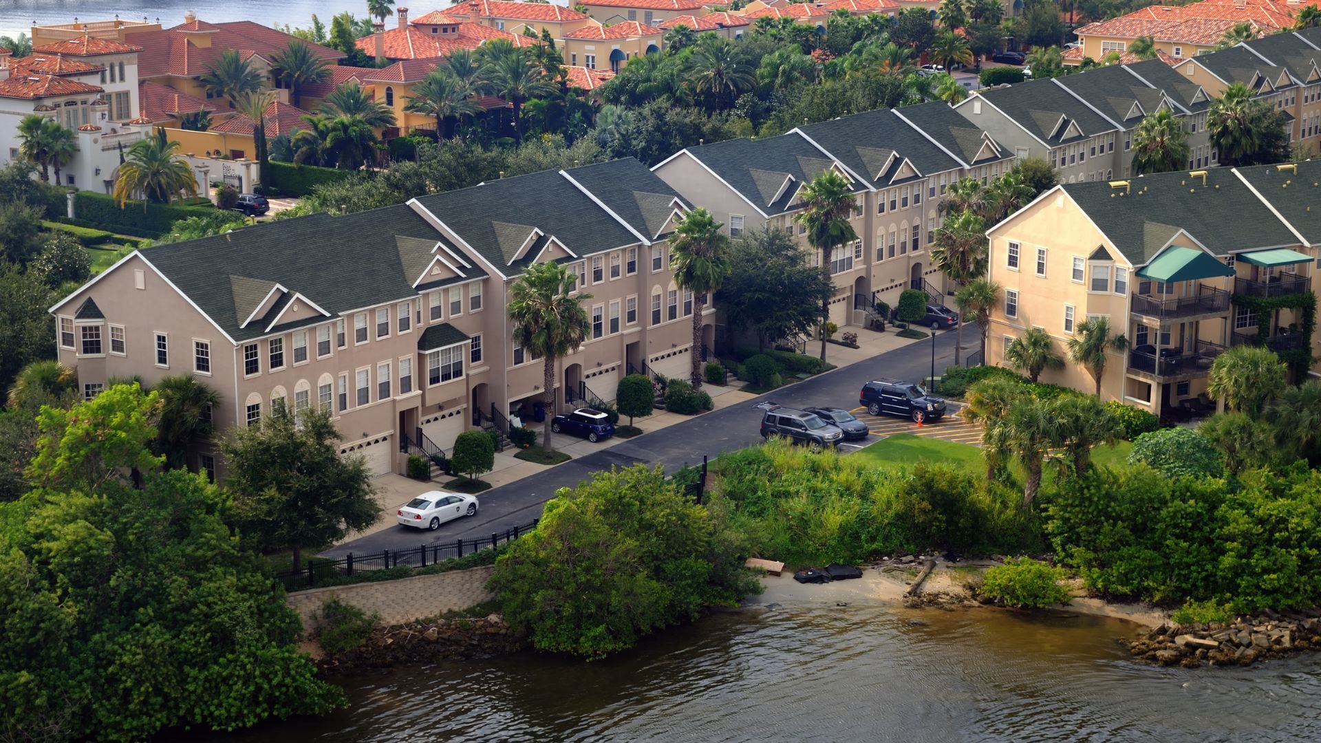 An aerial view of a row of houses next to a body of water
