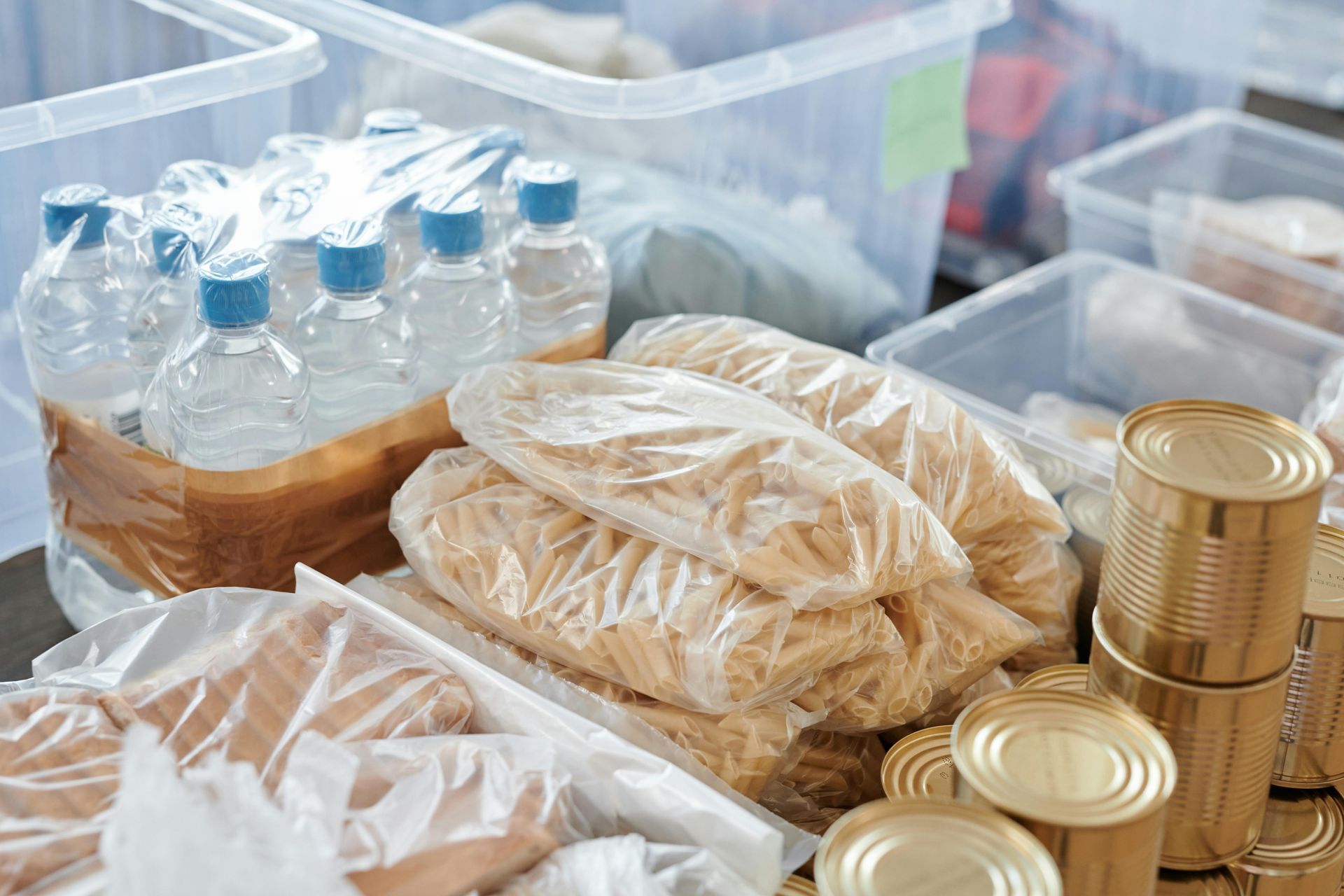 Food donation items: water bottles, pasta, canned goods, and packaged food in containers.