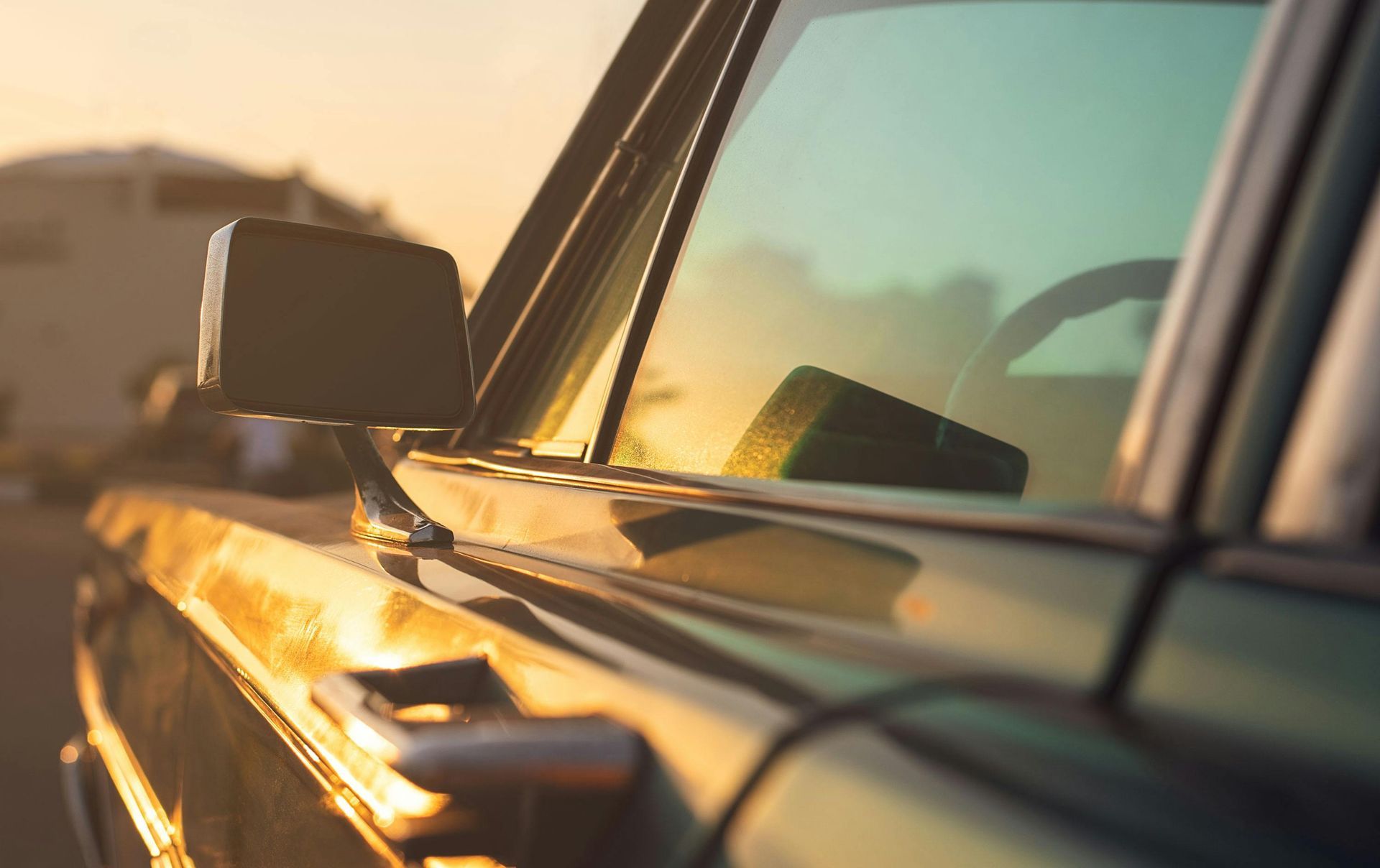 A car is parked on the side of the road at sunset.