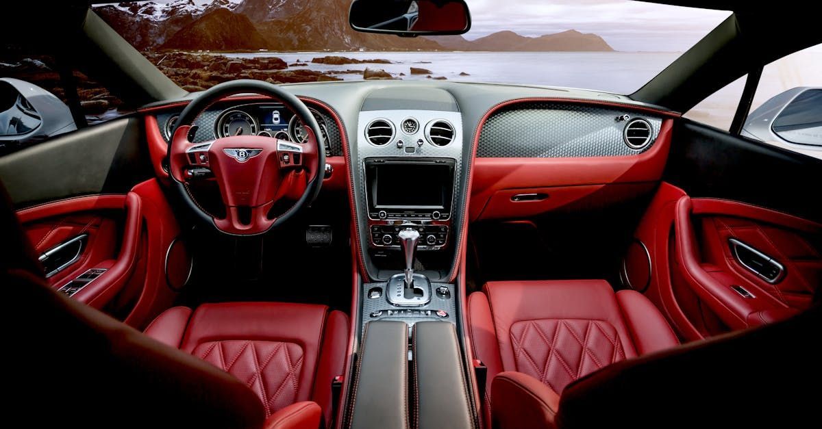 The interior of a car with red seats and a steering wheel.