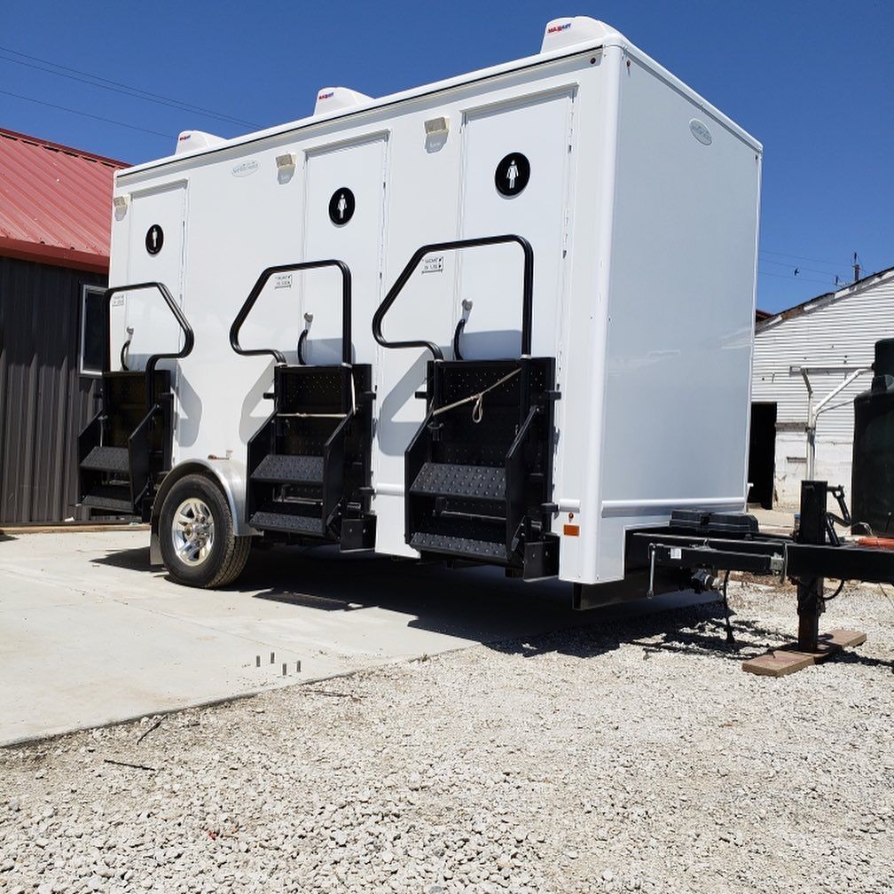 A white trailer is parked in a gravel lot