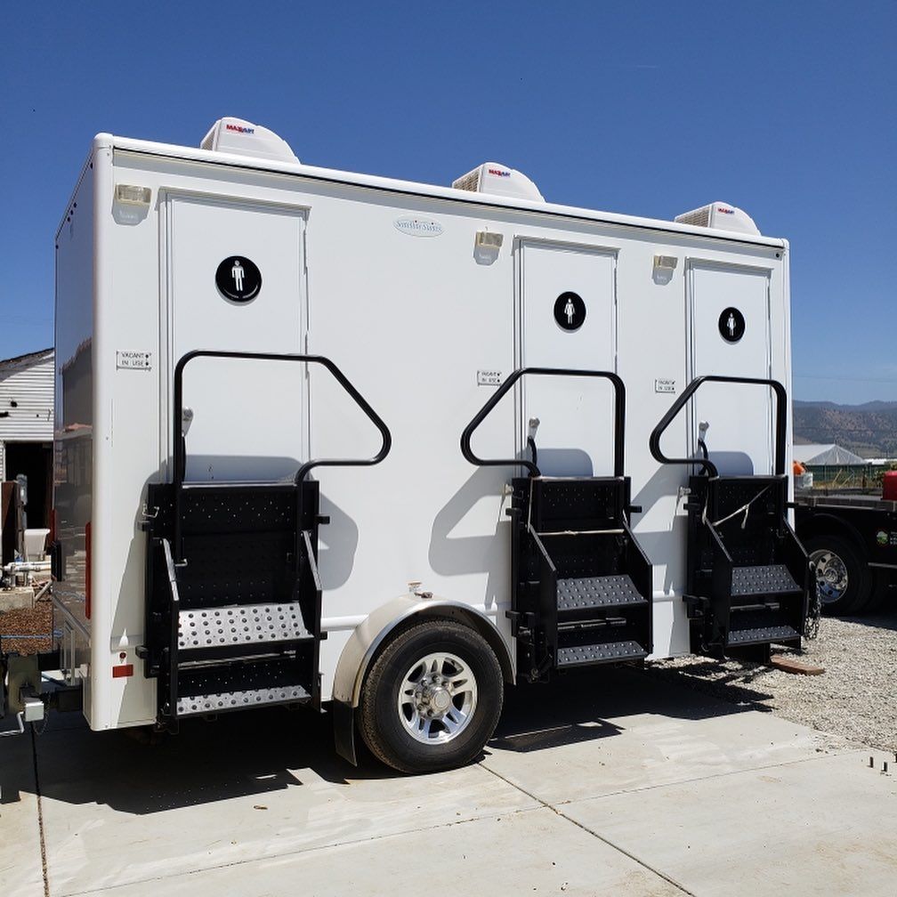 A white trailer with two toilets and stairs on it