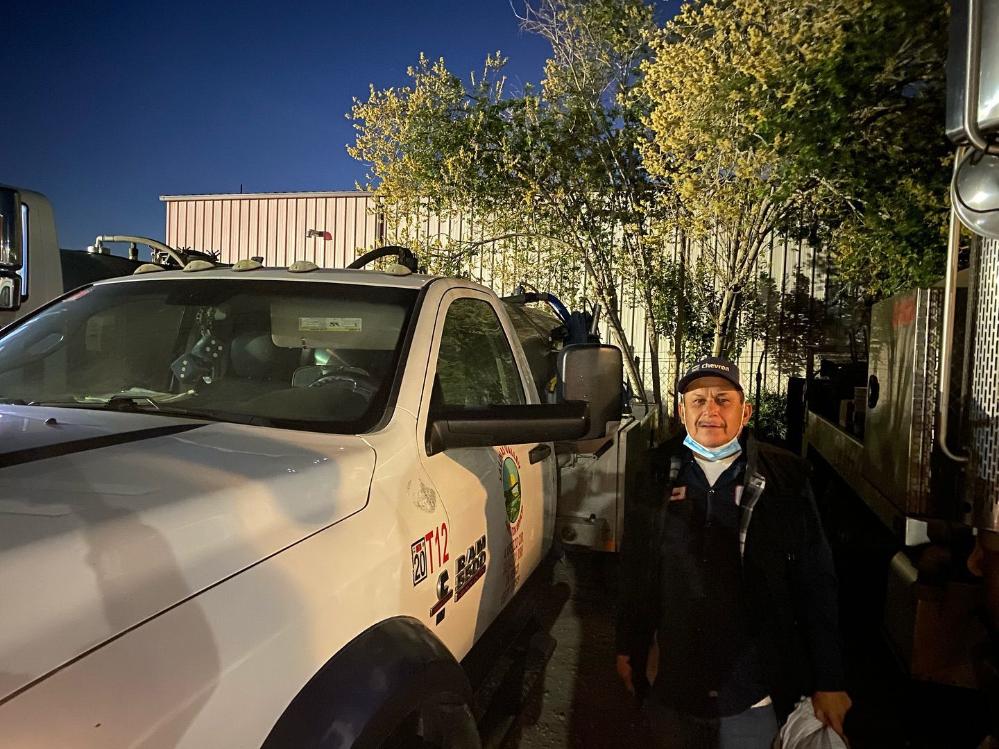 A man is standing in front of a white truck.