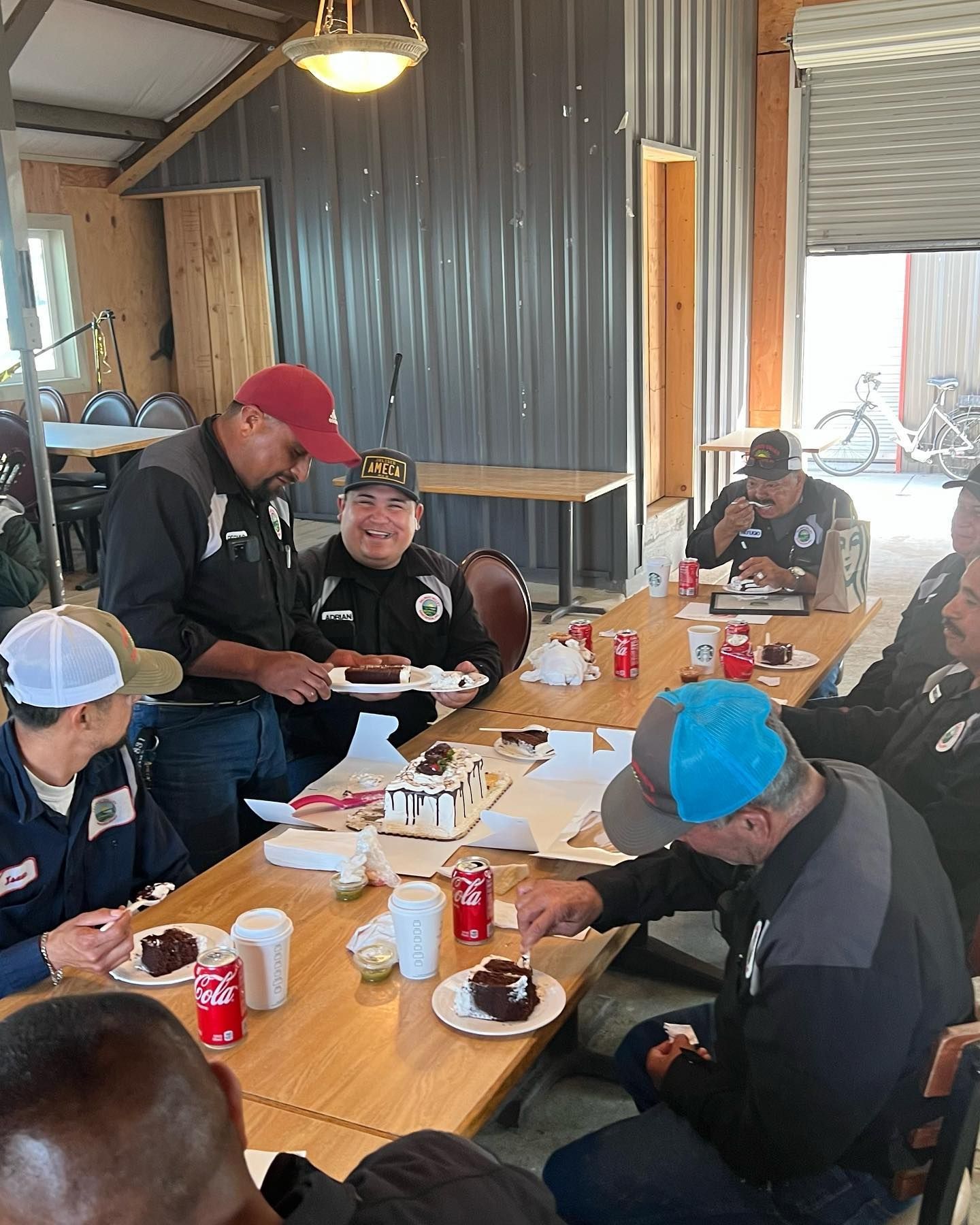 A group of men are sitting around a table eating food.