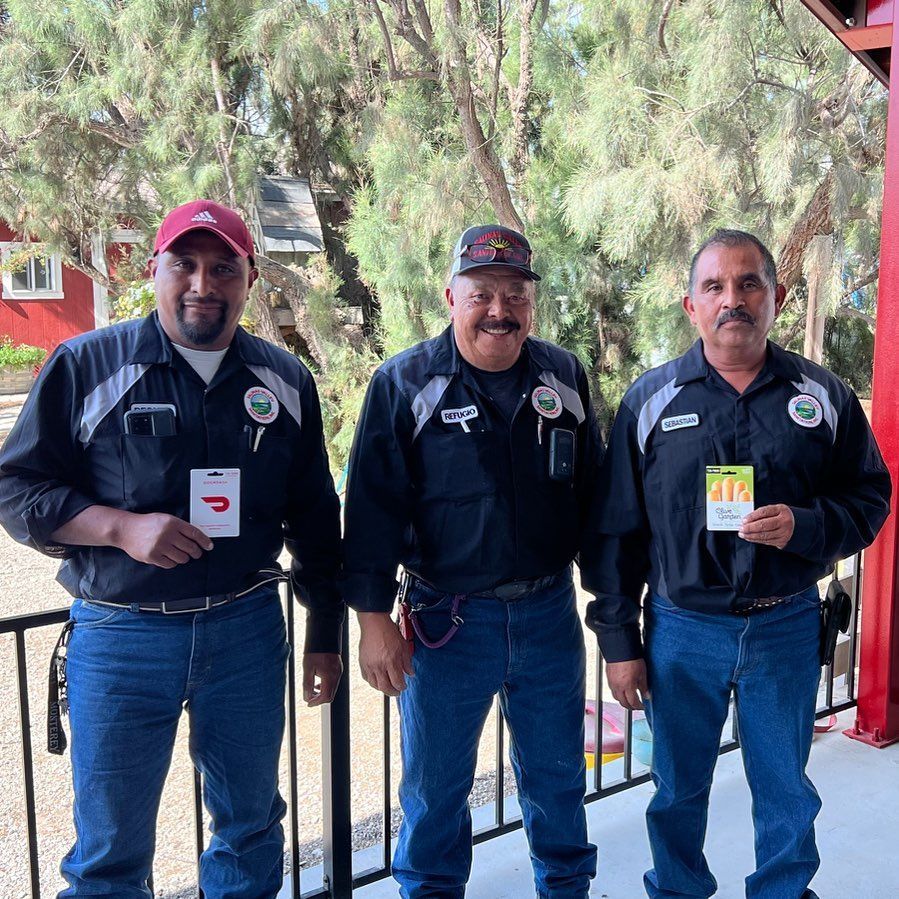 Three men are standing next to each other on a balcony and one of them is wearing a name tag with the letter d on it