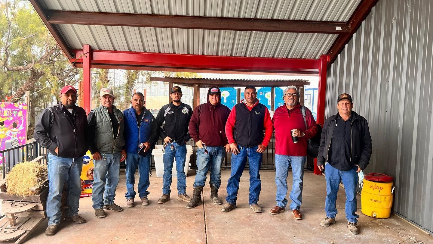 A group of men are standing under a covered area.