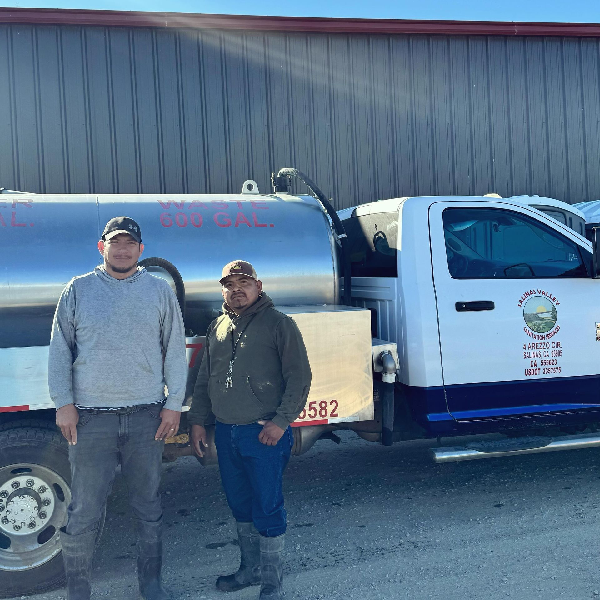 Two men standing in front of a truck with the number 582 on it