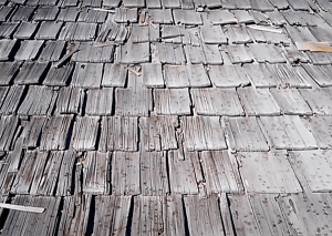 Close-up view of weathered wooden roof shingles in shades of gray.