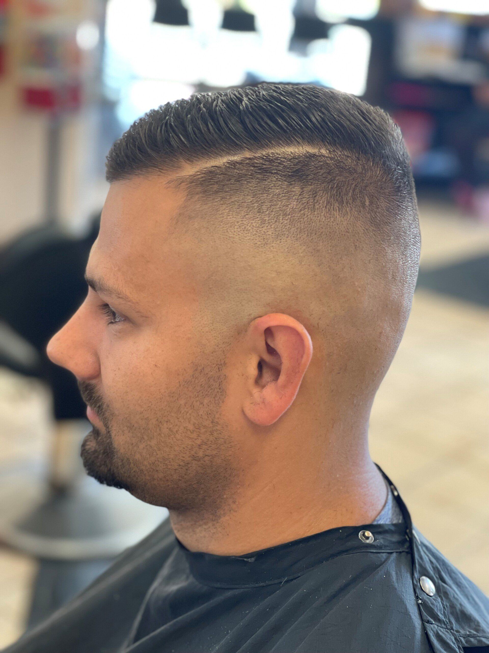 A man is getting his hair cut at a barber shop.