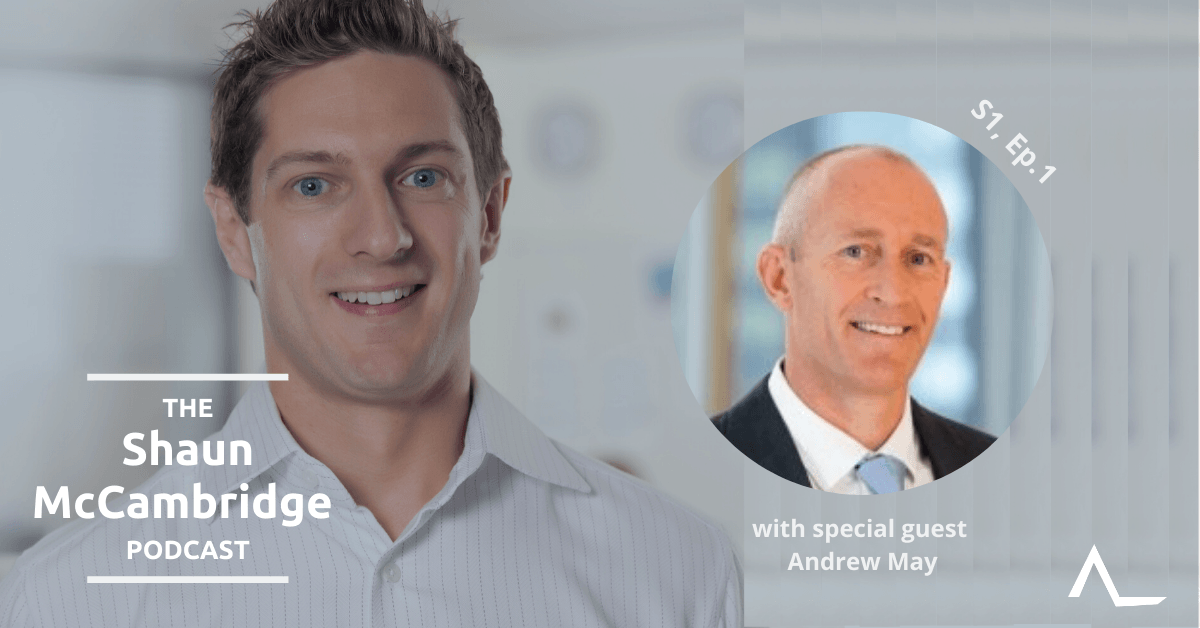 Shaun McCambridge podcast episode 1: Shaun smiles next to a portrait of Andrew May, against a blurred backdrop.