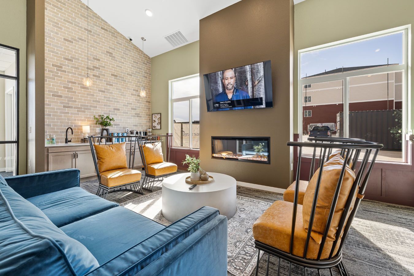 a living room with a couch , chairs , table and television .