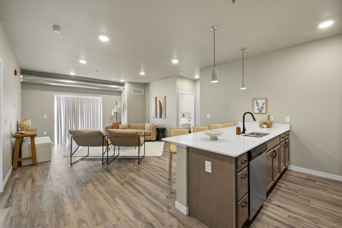 a living room with hardwood floors and a kitchen with a large island .