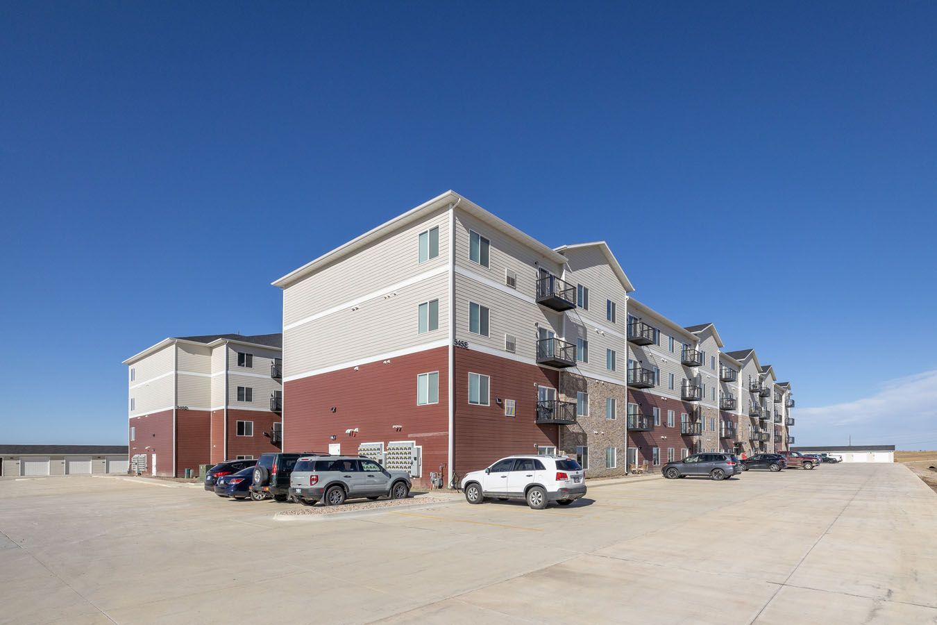 a large apartment building with cars parked in front of it .