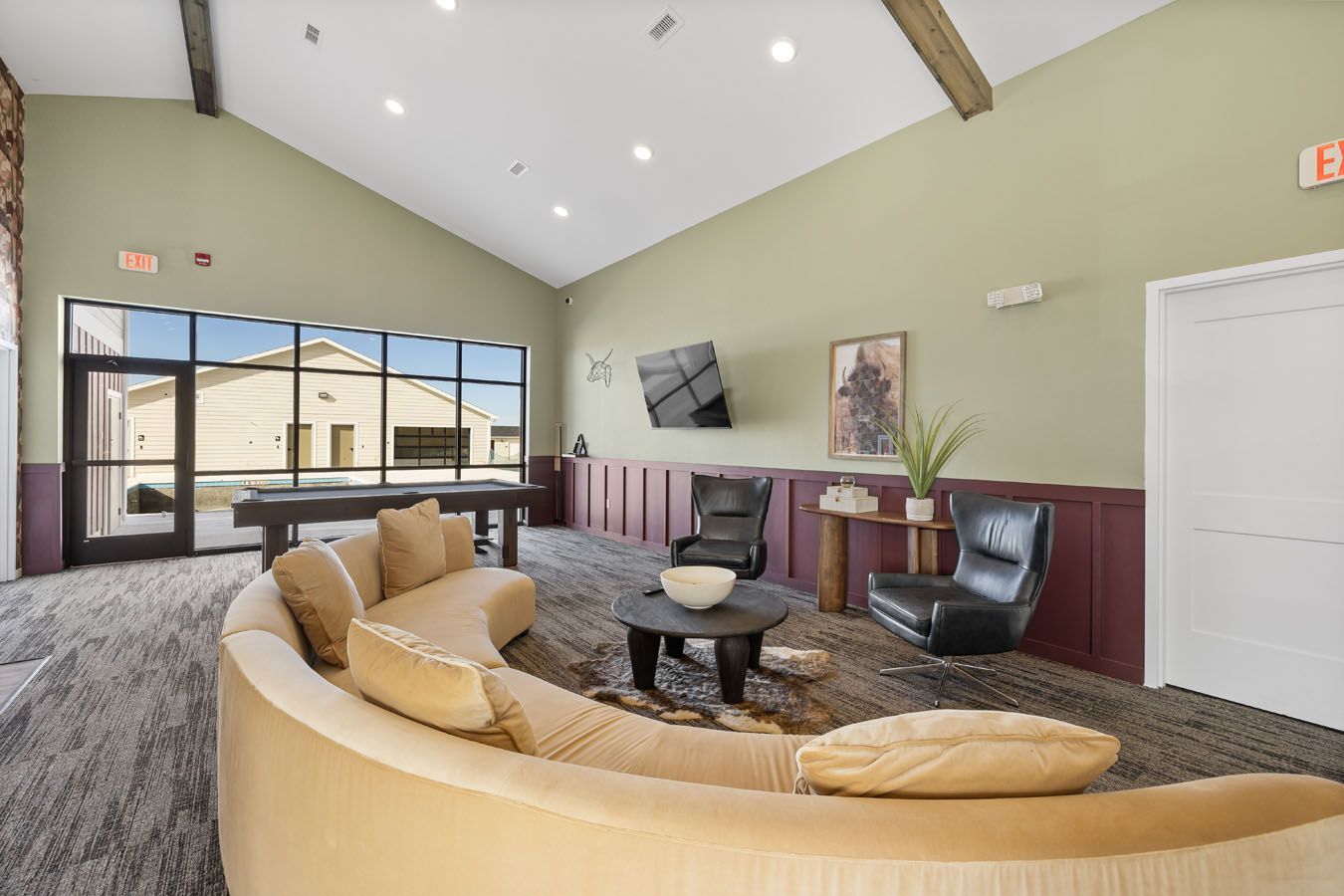 a living room with a couch , chairs , table and pool table .