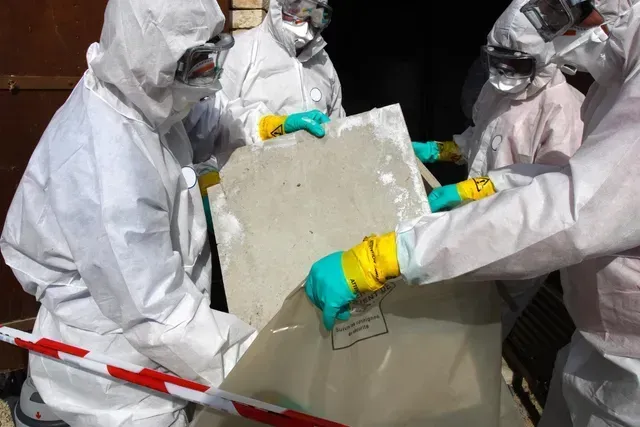 A group of technicians is collecting removed asbestos fibers for disposal in Columbia.