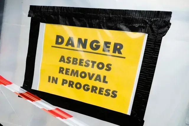 A sign is posted in Columbia warning people that asbestos removal is in progress.