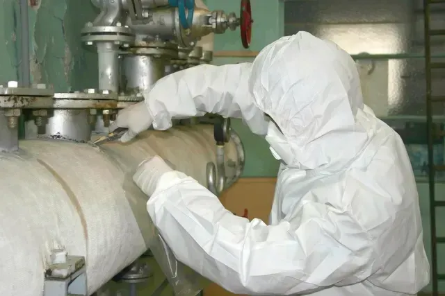 A technician from ABC Environmental Contracting Services in Columbia is removing asbestos fiber from a pressure line.