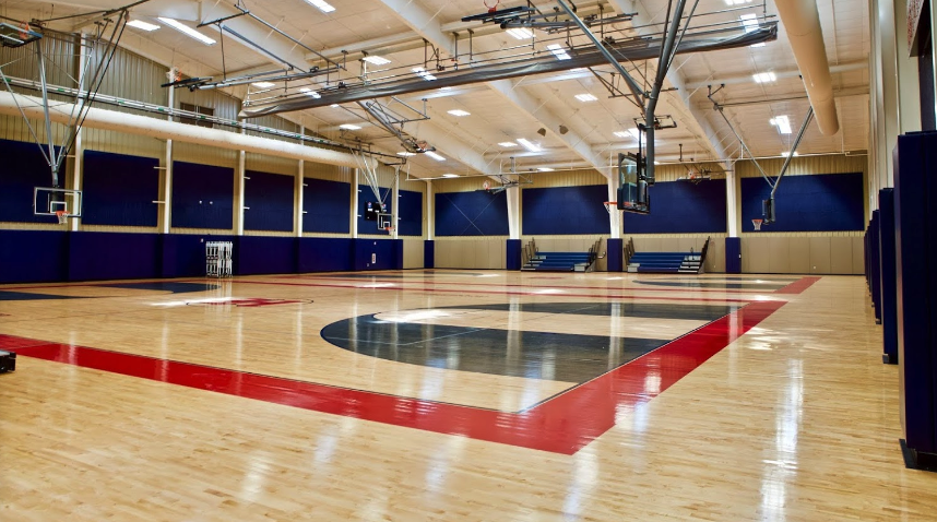 An empty basketball court with a red and white stripe on the floor