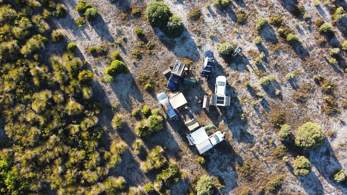 4WD off-grid camping setup in remote Western Australia bush with touring vehicles and rooftop tents