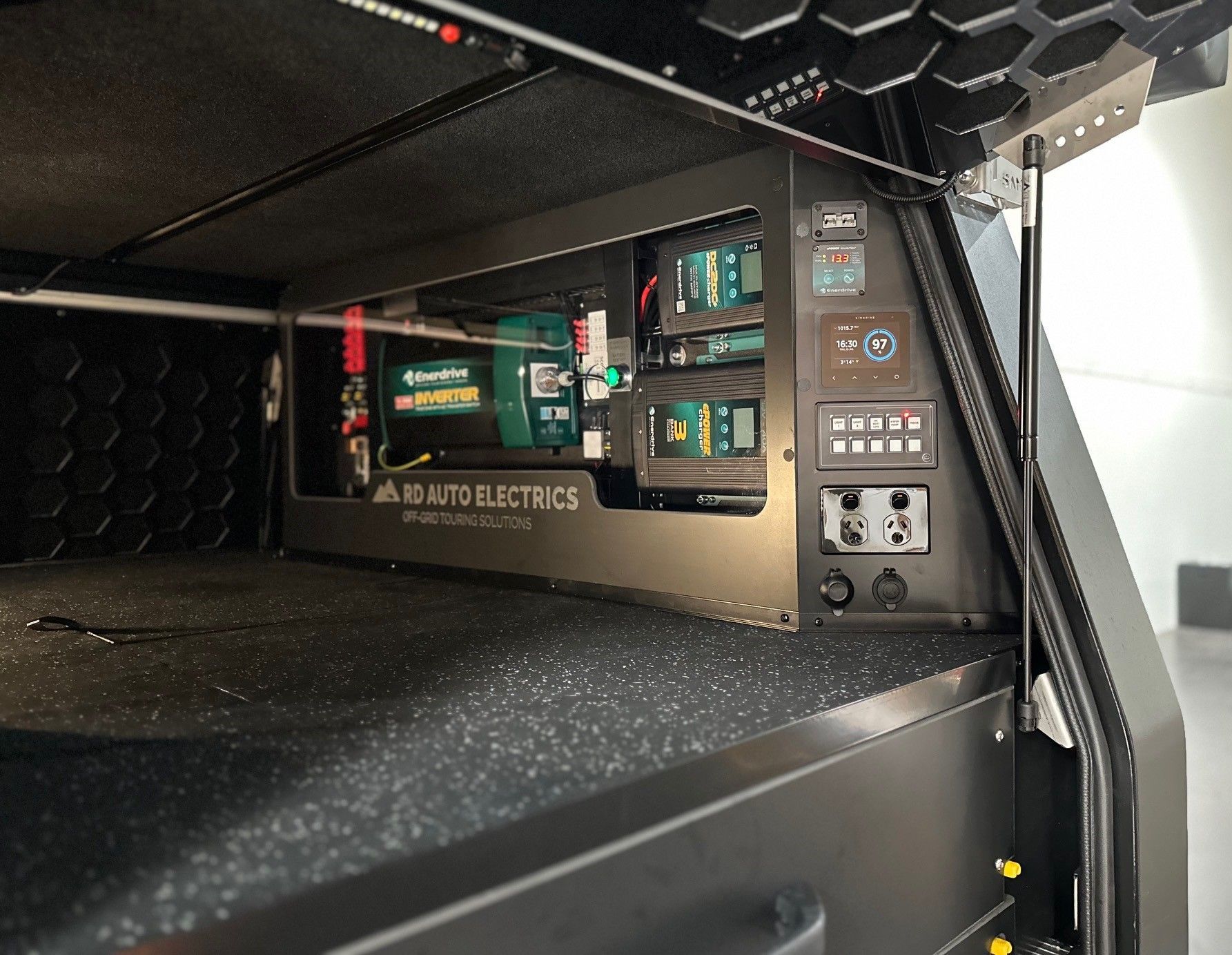 Off-grid 4WD canopy electrical setup with inverter, battery monitor and charging system for remote travel.