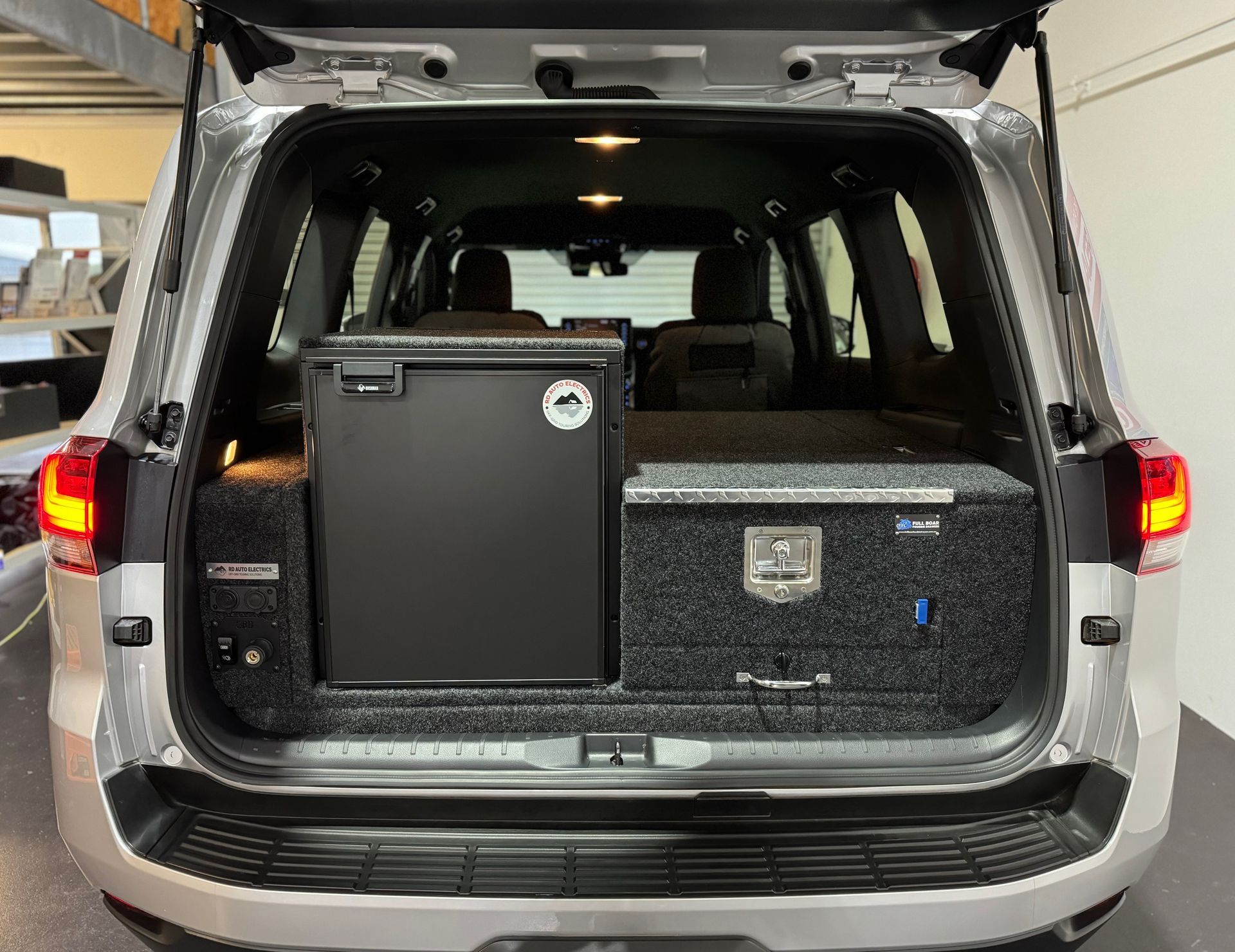 Toyota LandCruiser rear drawer system with integrated fridge and 12V power outlets for off-grid touring and camping.