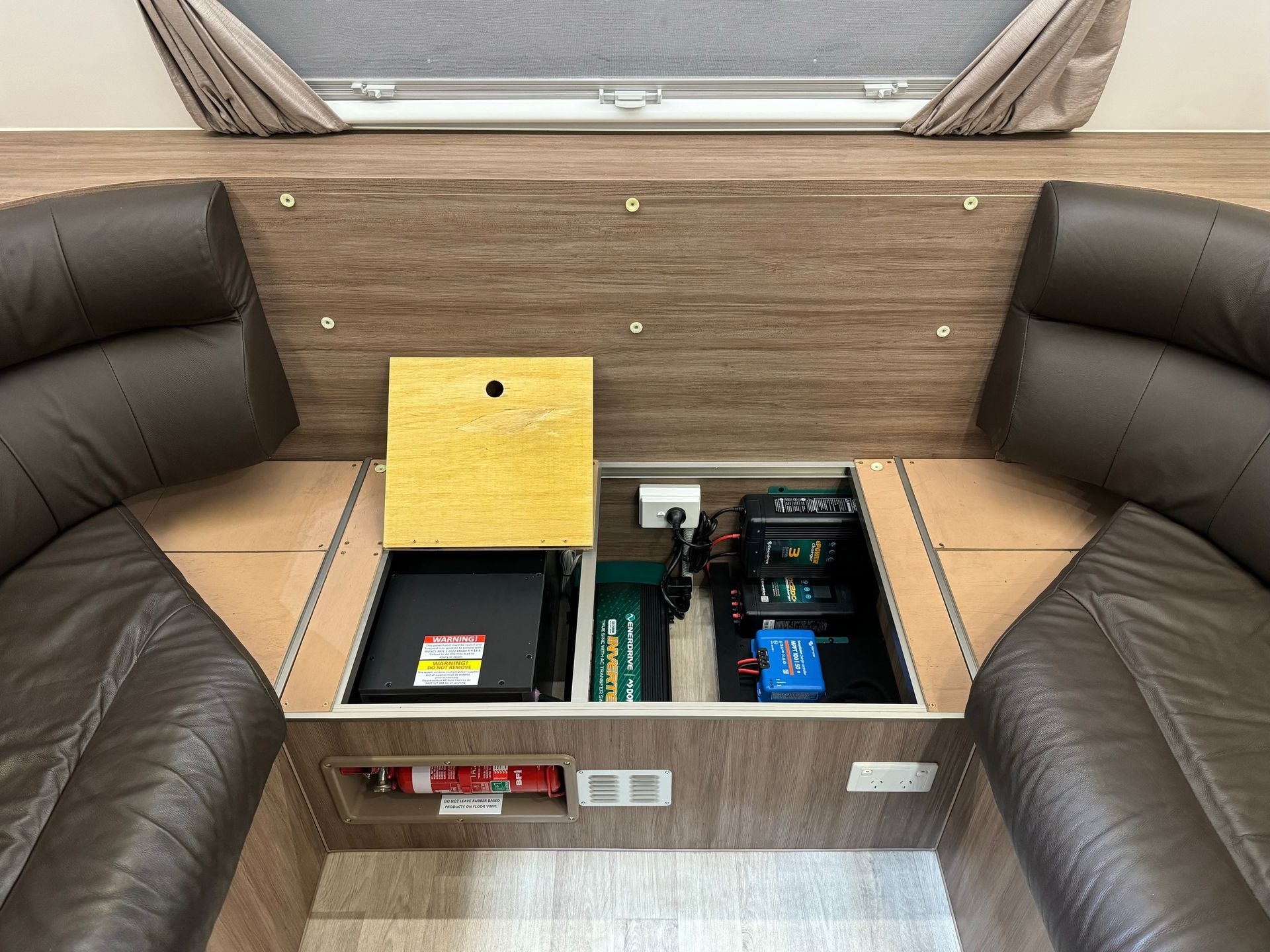 Caravan under-seat power system with lithium battery, inverter and charging components for off-grid energy storage.