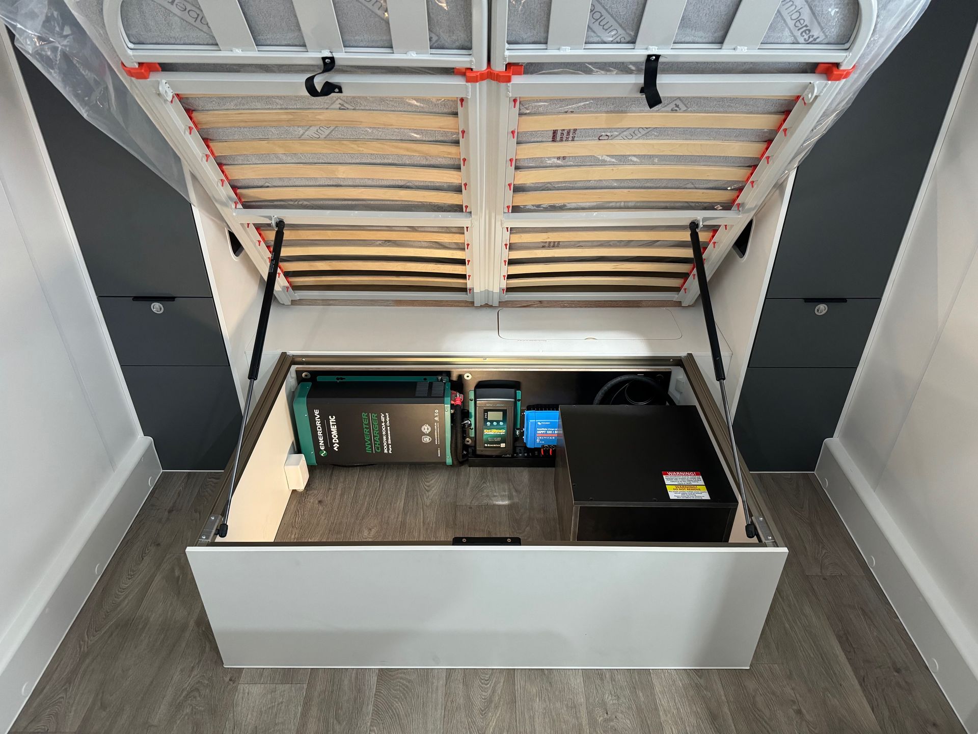 Under-bed RV electrical setup with inverter and lithium battery for dependable off-grid camping power.