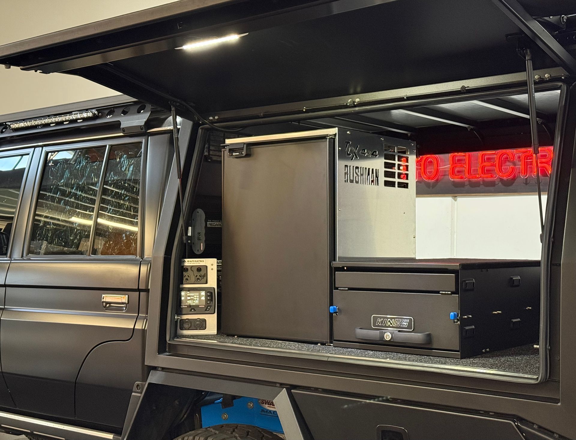 Canopy touring setup with Bushman fridge, storage drawers and 12V power system installed in 4WD ute for off-grid travel.