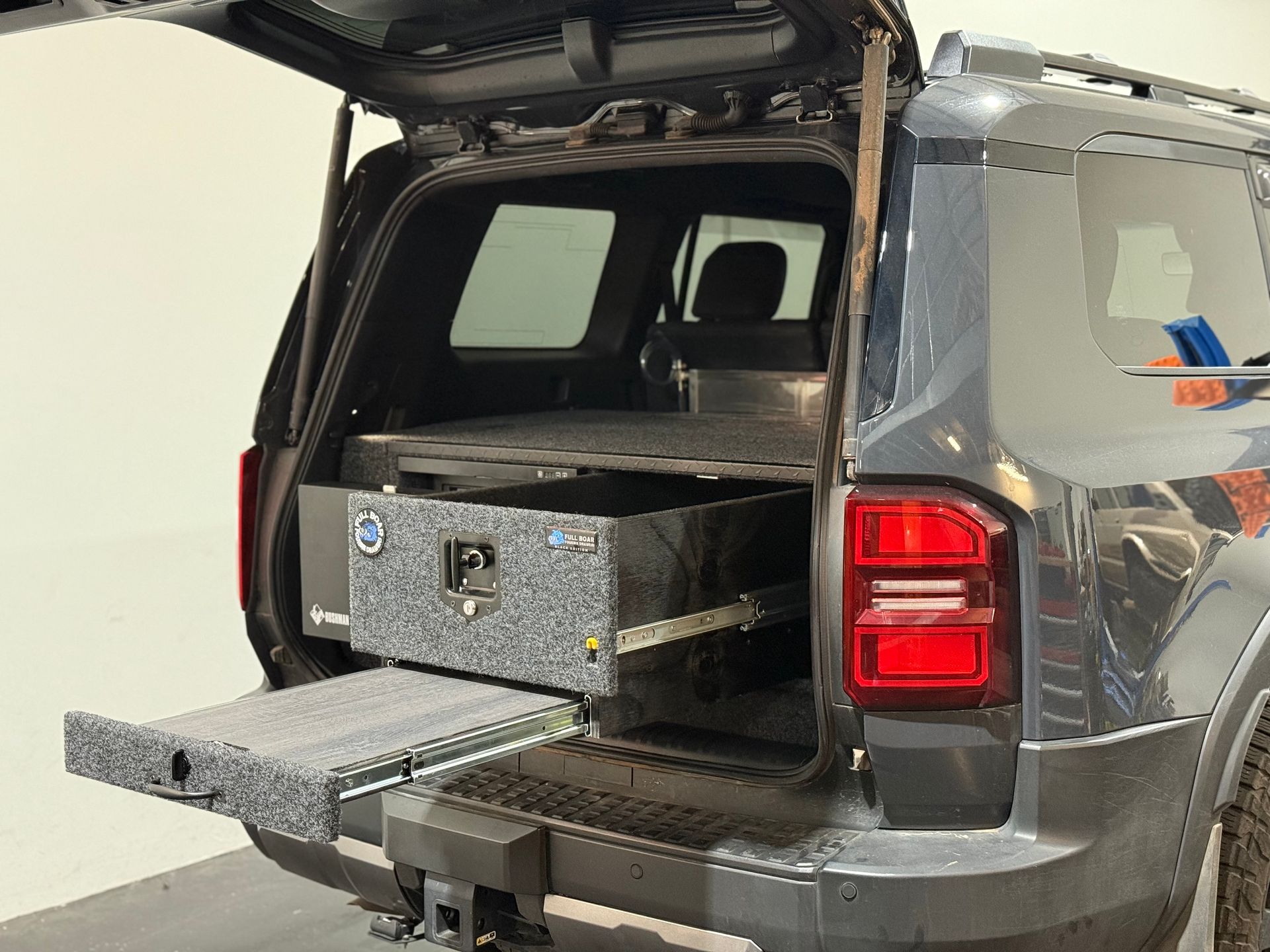 Touring drawer setup in 4WD wagon featuring slide-out fridge and custom, heavy-duty storage system.