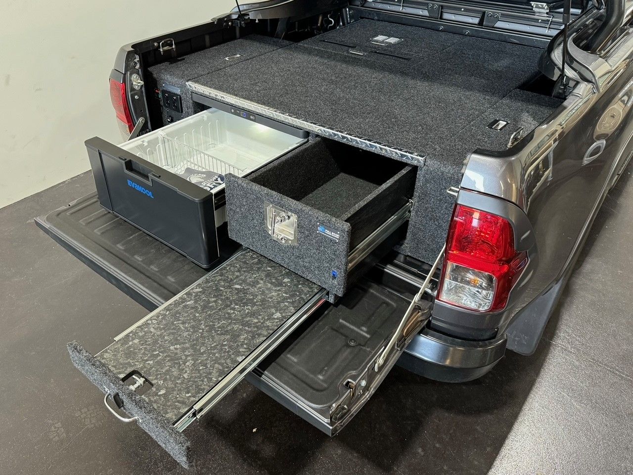 Touring drawer setup with fridge slide and work surface designed for off-road and overlanding vehicles.