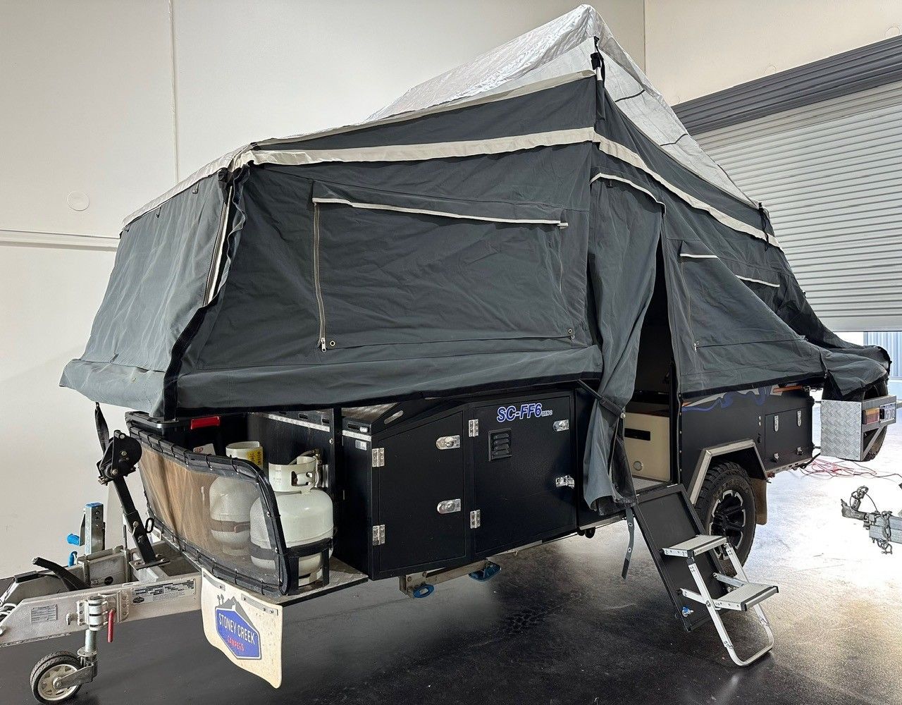 Off-road camper trailer with rooftop tent and off-grid power setup for remote touring and camping.